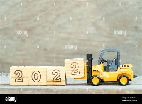 Toy Forklift Hold Letter Block To Complete Word On Wood