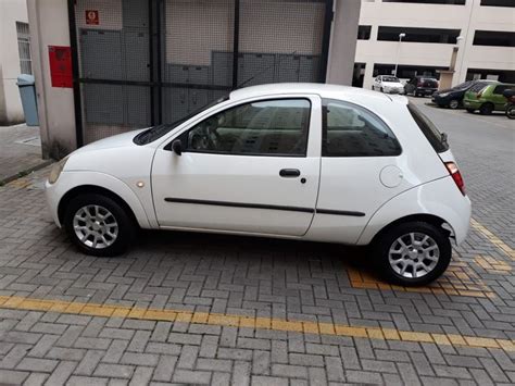 A Small White Car Parked In Front Of A Building