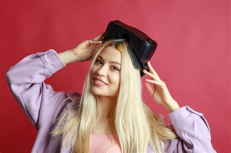 Premium Photo Beautiful Blonde Smiling And Wears Vr Glasses On Red