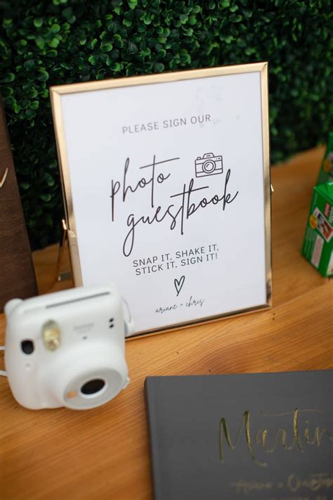 There Is A Sign That Says Photo Guestbook Next To A Camera And Other