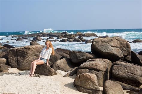 Portrait de jeune femme en bikini blanc sur la plage tropicale en regardant la caméra Belle