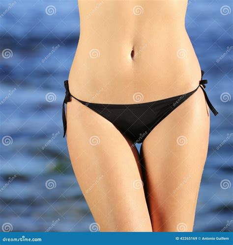 Vista Delantera De Las Caderas Perfectas De Una Mujer Que Llevan El Bikini En La Playa Imagen De