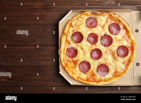 Tasty Pepperoni Pizza In Cardboard Box On Wooden Table Top View Space