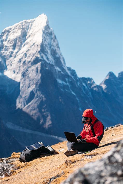 "Man Using Laptop In Mountain" by Stocksy Contributor "Marko" - Stocksy