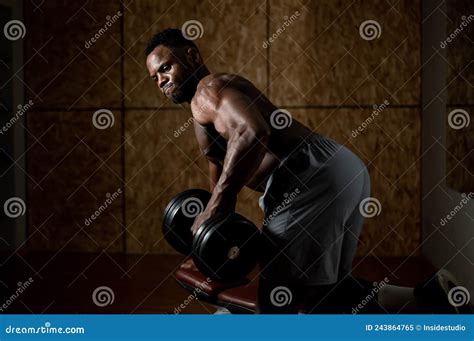 African American Man With Naked Torso Doing Triceps Row With Dumbbell