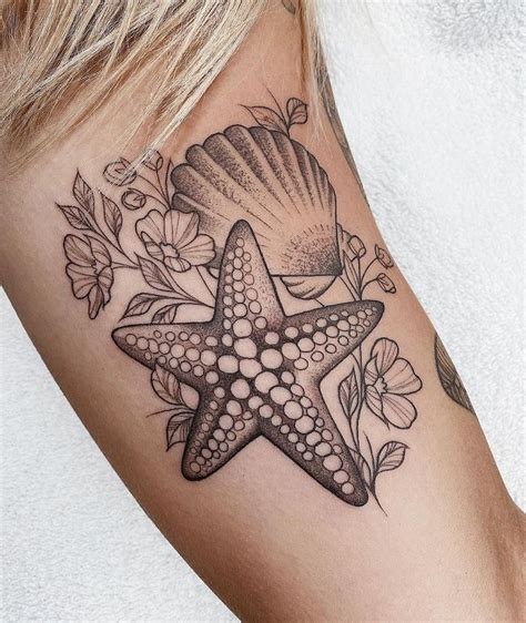 A Starfish And Seashell Tattoo On The Right Side Of The Left Arm With