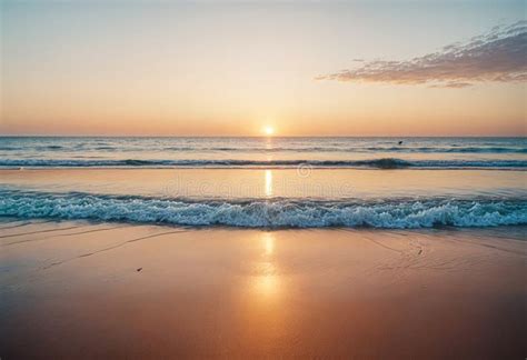 A Sunset Is Reflected Over The Ocean With Waves On The Beach Stock