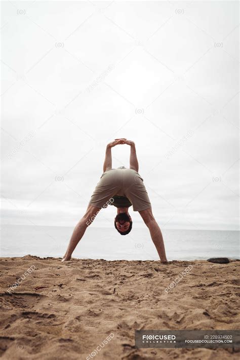 Hombre Realizando Ejercicio De Estiramiento En La Playa Bienestar