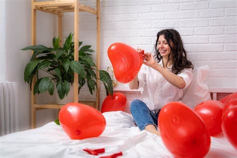 Girl Is Blowing Air Balloon At Home Handsome Brunette Girl Inflating Red Heart Shaped Balloon