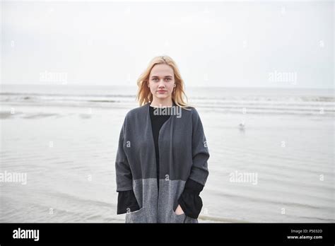 Jeune femme blonde debout sur la plage Banque de photographies et dimages à haute résolution