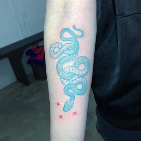 Freehand blue snake tattoo on the right inner forearm.