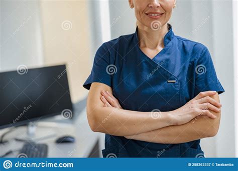 Close Up Of Doctor In Uniform Standing With Crossing Hands In Clinic