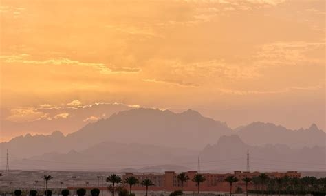 Paisaje Al Atardecer Con Complejo Hotelero Remoto Contra Picos