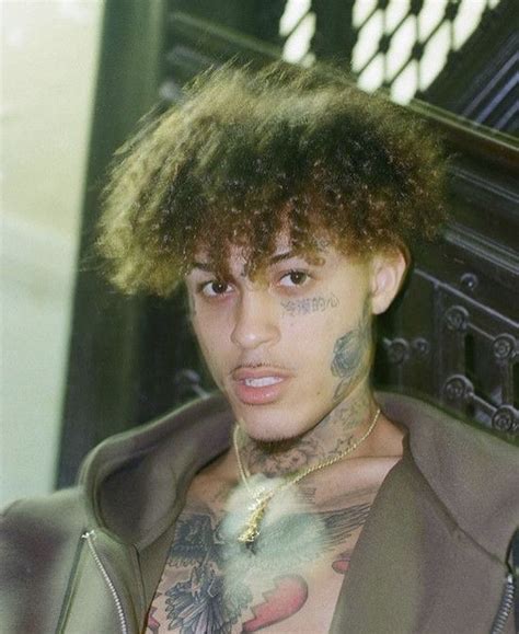 A Man With Tattoos On His Chest Wearing A Jacket