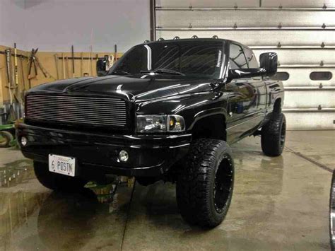 A Large Black Truck Parked In A Garage