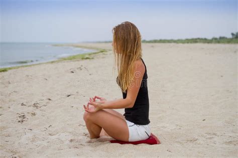 Muchacha Hermosa En El Bikini Que Sienta Y Que Mira El Mar Yoga Y Hacer Frente Al Amanecer Foto