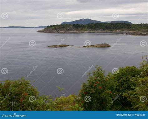 A Body Of Water That Is Surrounded By Mountains And Trees Stock Photo