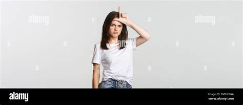 Sad And Disappointed Brunette Girl Showing Loser Gesture And Sulking White Background Stock