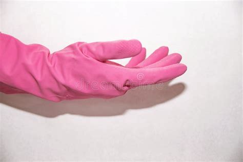 The Pink Glove Dressed On A Hand Shows An Index Finger Down On A White