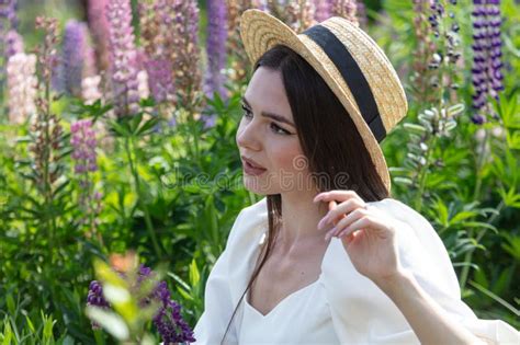 Portrait Of A Brunette Girl In A Straw Hat Outdoors In Summer Stock