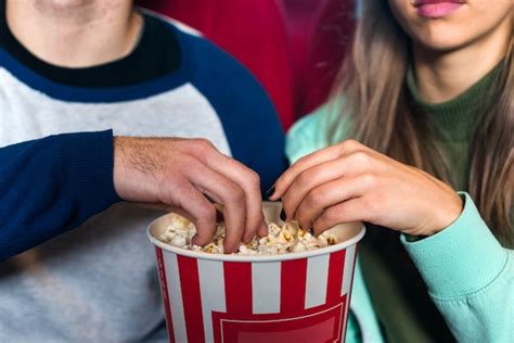 Free Photo Couple Eating Popcorn In Cinema