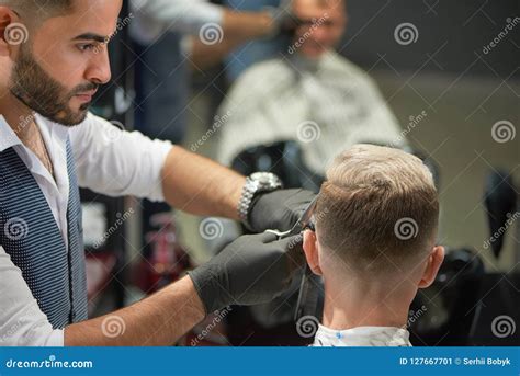 Handsome Barber In Black Gloves Cutting Haircut Of Man Using Scissors