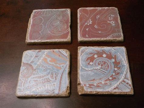 Four Stone Coasters Sitting On Top Of A Wooden Table