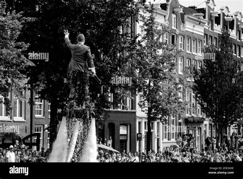 L homme en flyboard en costume mouillé s élève bien au dessus de la foule pendant la fierté gay
