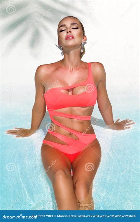 Elegant Woman In Bikini On The Sun Tanned Slim And Shapely Body Is