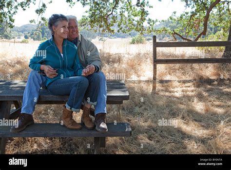 Mature Couple Sitting On Picnic Table Stock Photo Alamy