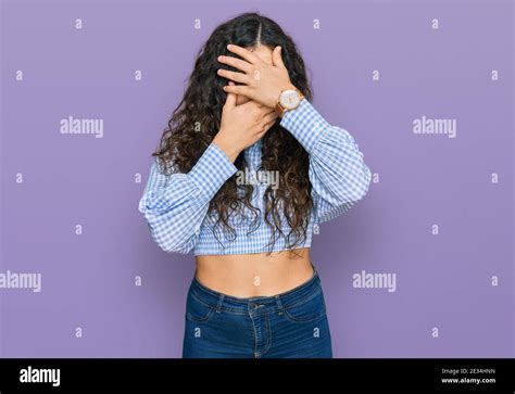 Young Hispanic Girl Wearing Casual Clothes Covering Eyes And Mouth With