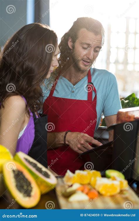 Shop Assistants Discussing With Digital Tablet At Health Grocery Shop