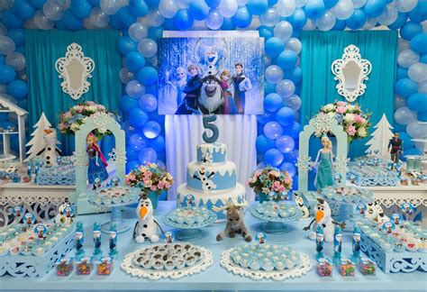 Foto da mesa e painel da festa infantil tema da frozen A foto é