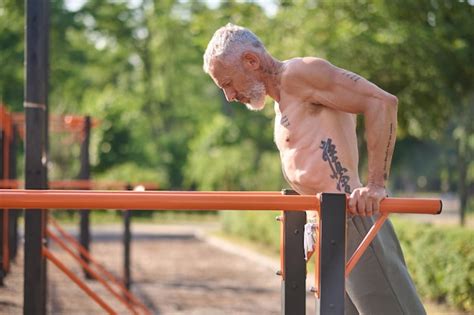 Premium Photo A Mature Gray Haired Man Exercising In The Park