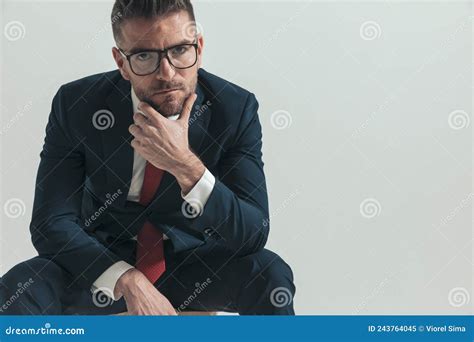 Thoughtful Man In His Forties With Glasses Holding Hand To Chin And Wondering Stock Image