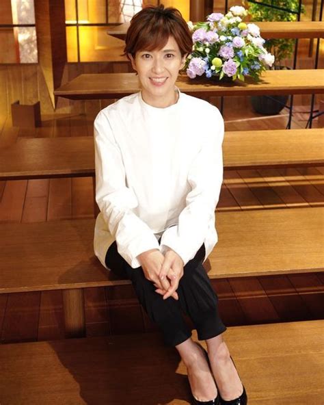 A Woman Is Sitting On The Steps In Front Of Some Stairs With Flowers