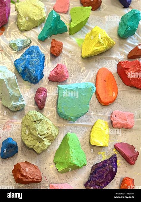 Several brightly rainbow colored rocks on white background Stock Photo - Alamy