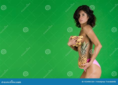 Muchacha Atractiva En Bikini Con El Plátano Y La Piña Foto de archivo