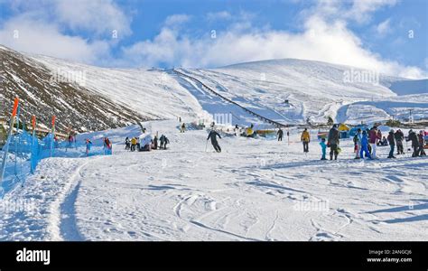 Men, women and children on sunny snow slopes at Cairngorm Mountain Ski Centre Cairngorms ...