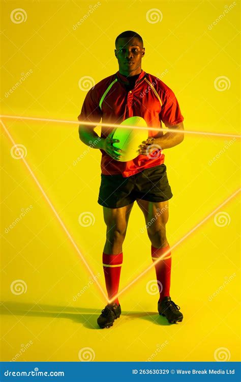 Confident African American Male Rugby Player With Ball By Illuminated