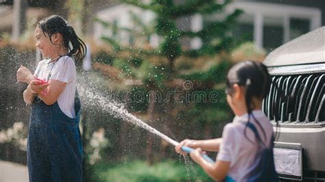 Sibling Asian Girls Wash Their Cars And Have Fun Playing Indoors On A Hot Summer Day Stock Image