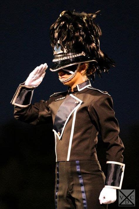 A Woman In A Uniform Is Holding Her Hand Up To Her Face As She Walks