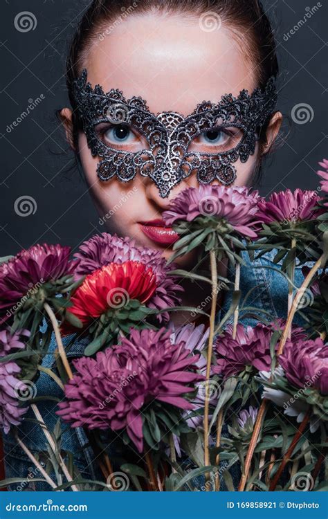 Mysterious Young Woman In Venetian Mask With Flowers Stock Image