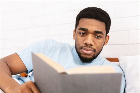 Homem Negro Que Estuda A Literatura Do Neg Cio Na Cama Imagem De Stock