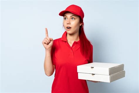 Premium Photo Pizza Delivery Girl Holding A Pizza Over Isolated Wall Thinking An Idea Pointing