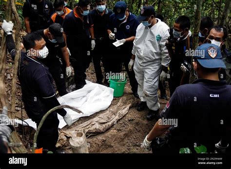 Malaysian Police Forensic Team Members Inspect A Freshly Exhumed Human