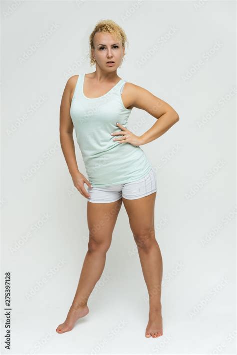 Full Length Portrait Of A Beautiful Blonde Woman Girl With Short Curly Hair On A White