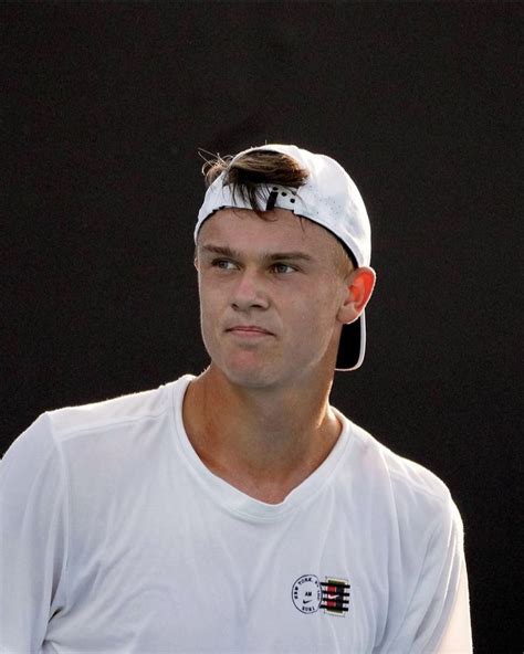 A Male Tennis Player In A White Shirt And Headband