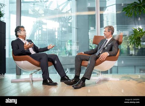 Two Businessmen Talking In Office Stock Photo Alamy