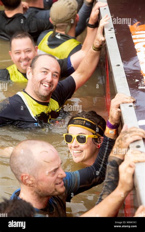 Contestants In The ‘block Ness Monster Obstacle At The Tough Mudder